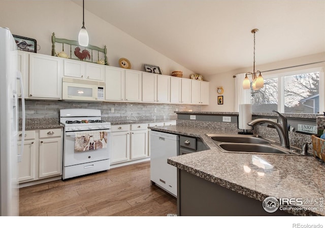 kitchen with a sink, backsplash, white appliances, and lofted ceiling