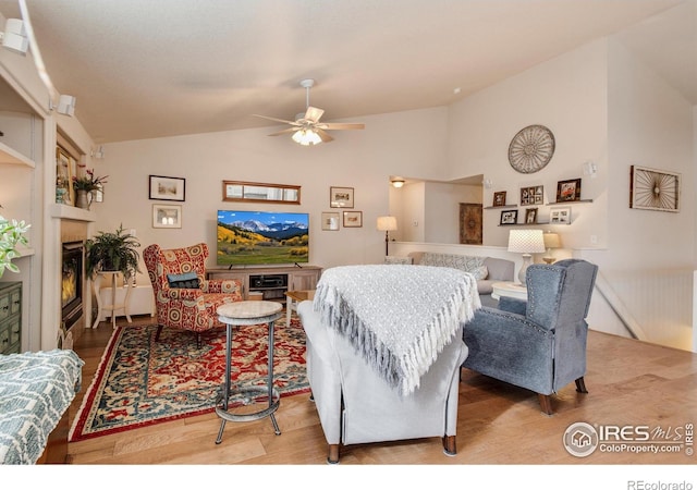 living room featuring ceiling fan, vaulted ceiling, and wood finished floors