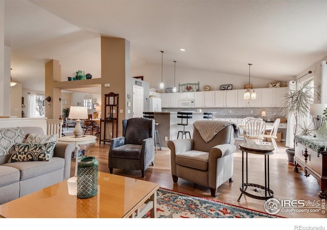 living room with vaulted ceiling and wood finished floors