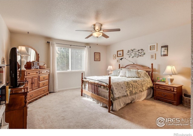 bedroom featuring a textured ceiling, ceiling fan, and light carpet
