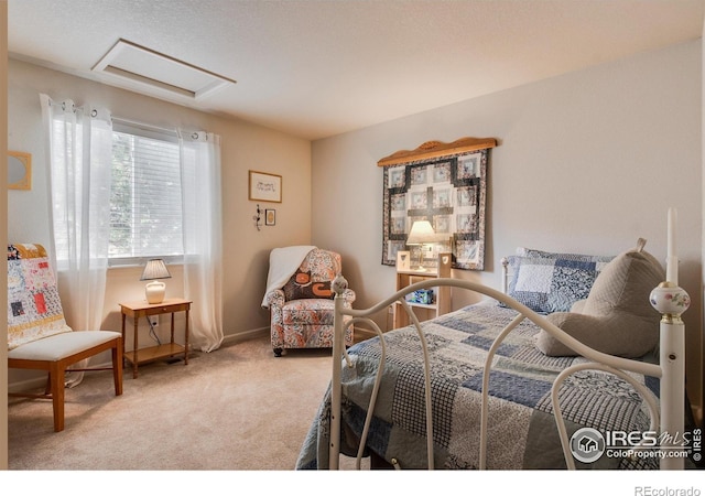 carpeted bedroom with baseboards and attic access