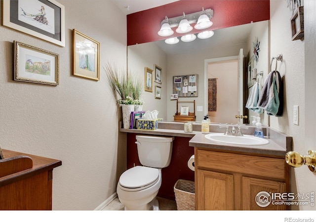 half bathroom featuring vanity and toilet