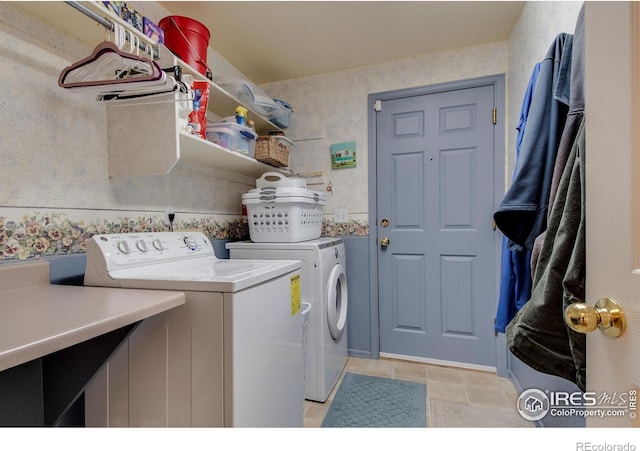 laundry area featuring laundry area, light tile patterned floors, washing machine and dryer, and wallpapered walls