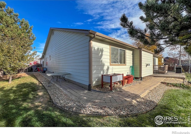 exterior space with fence, a wooden deck, and a yard