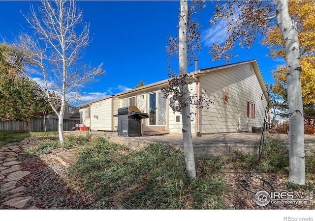 view of side of home featuring fence and a patio area
