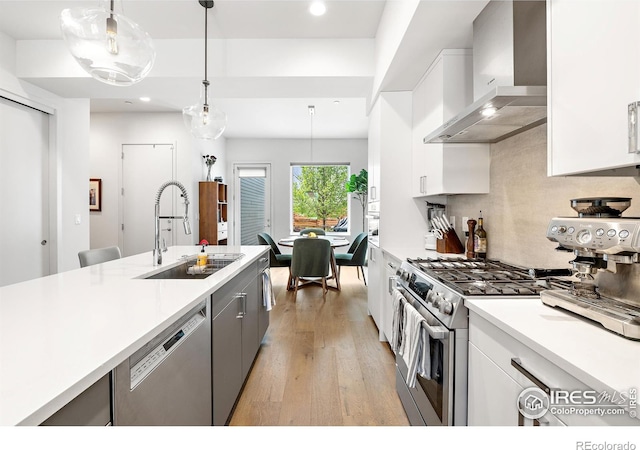 2907 32nd St, Boulder, CO 80301 - kitchen featuring wall chimney range hood, a sink, appliances with stainless steel finishes, light wood-type flooring, and white cabinetry