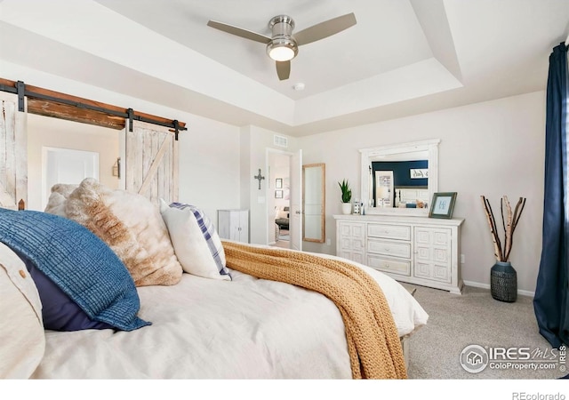 1977 Shadow Lake Ct, Windsor, CO 80550 - carpeted bedroom with a barn door, baseboards, a ceiling fan, and a tray ceiling