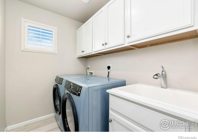 1977 Shadow Lake Ct, Windsor, CO 80550 - laundry room featuring cabinet space, independent washer and dryer, baseboards, and light wood finished floors