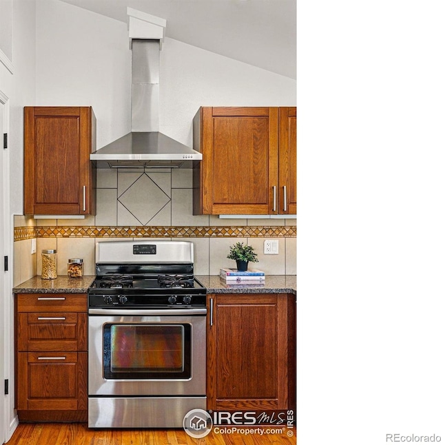 3812 Howe Ct, Boulder, CO 80301 - kitchen featuring stainless steel gas range oven, wall chimney range hood, tasteful backsplash, dark stone countertops, and brown cabinets
