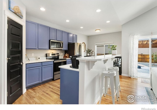 1689 Maseca Plaza Way, Severance, CO 80550 - kitchen featuring light countertops, a kitchen breakfast bar, light wood-style flooring, stainless steel appliances, and recessed lighting