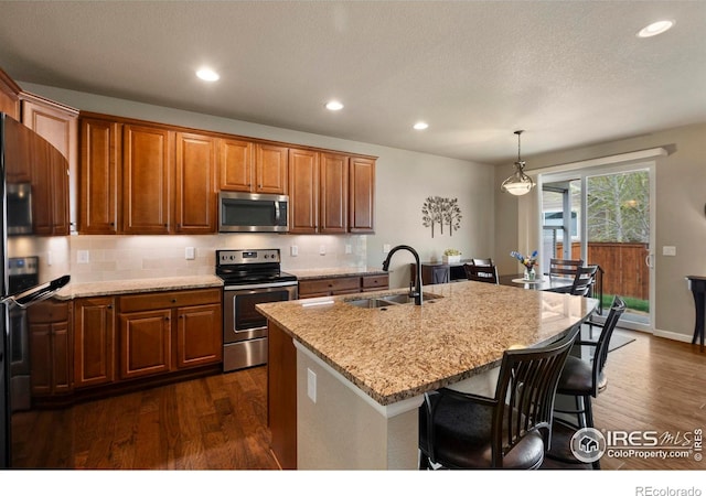 850 Prairiestar Dr, Berthoud, CO 80513 - kitchen featuring dark wood-style flooring, a kitchen breakfast bar, appliances with stainless steel finishes, and a sink