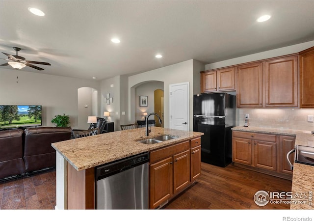 850 Prairiestar Dr, Berthoud, CO 80513 - kitchen featuring stainless steel dishwasher, freestanding refrigerator, arched walkways, a sink, and dark wood finished floors