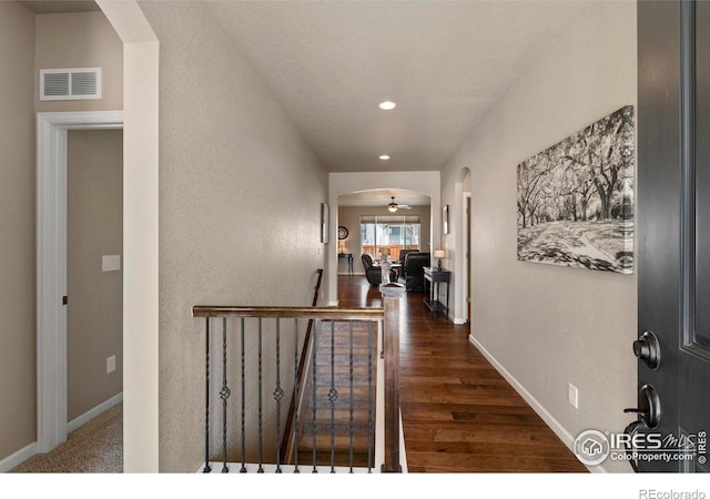 850 Prairiestar Dr, Berthoud, CO 80513 - hallway featuring visible vents, arched walkways, wood finished floors, an upstairs landing, and recessed lighting