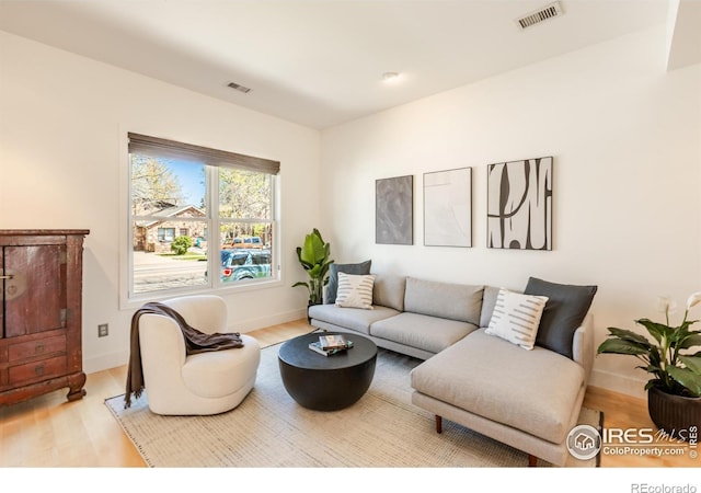 living room featuring visible vents and wood finished floors