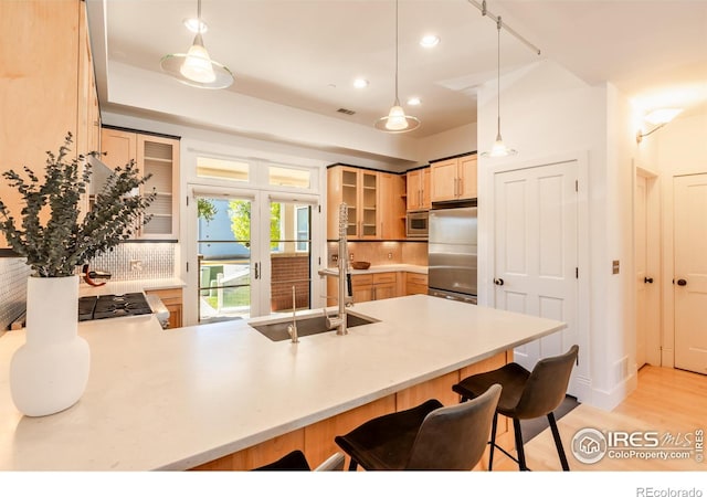 kitchen featuring appliances with stainless steel finishes, a breakfast bar, a peninsula, recessed lighting, and glass insert cabinets