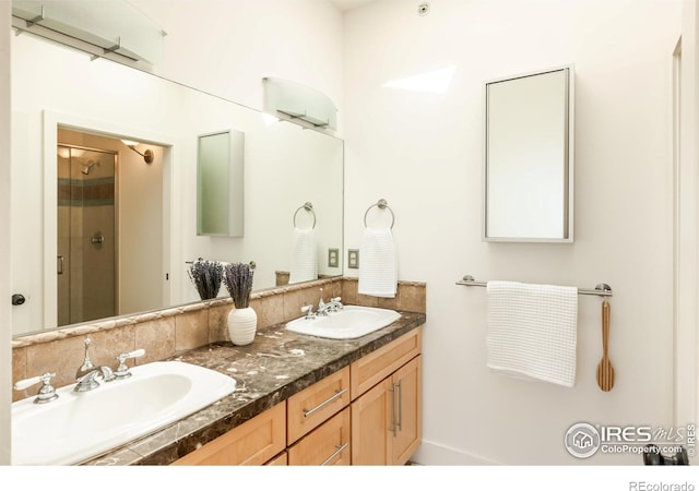 bathroom with a sink, a stall shower, and double vanity