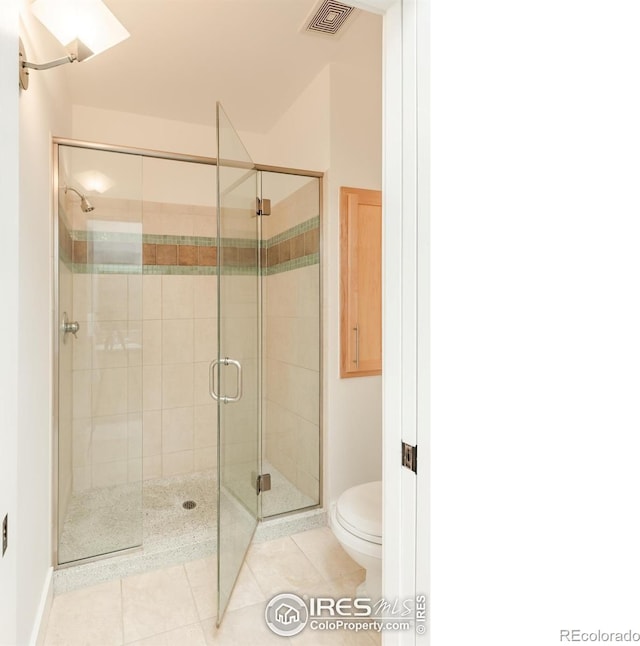 full bathroom featuring visible vents, toilet, baseboards, tile patterned floors, and a stall shower