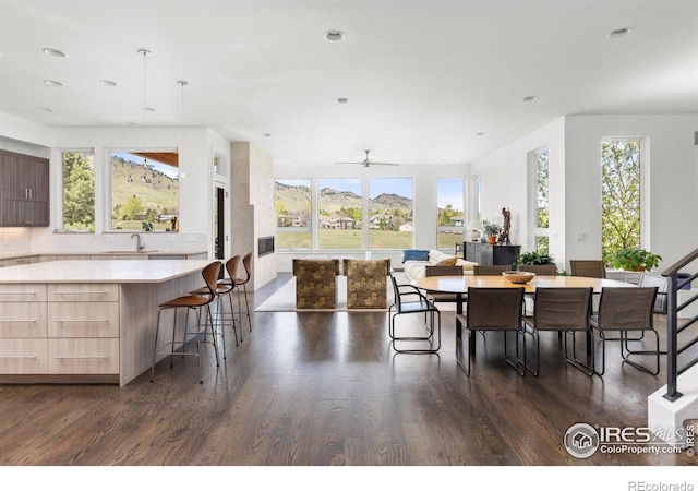 dining room with a mountain view, dark wood-type flooring, a ceiling fan, and recessed lighting