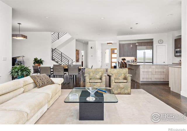 living area with stairway, recessed lighting, and dark wood finished floors