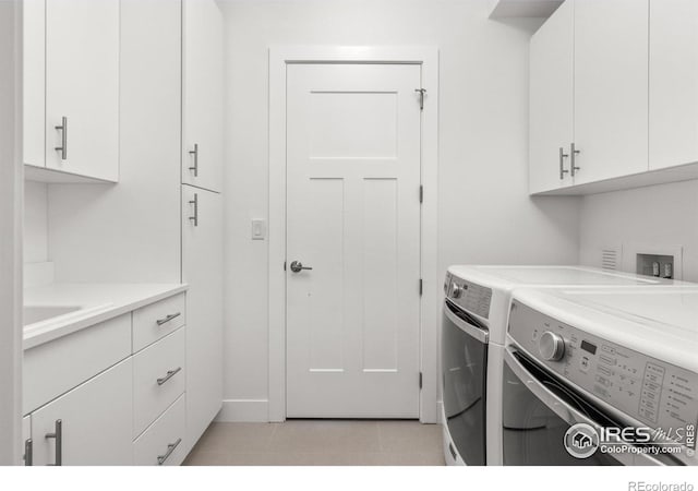 laundry room featuring washing machine and clothes dryer and cabinet space