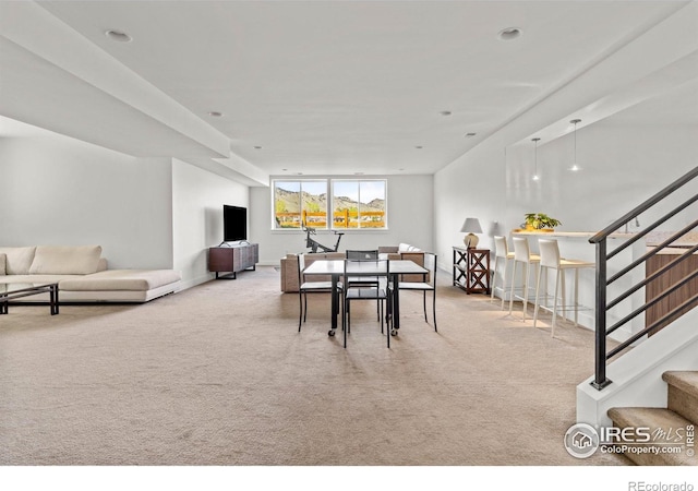 carpeted dining area featuring baseboards and stairway
