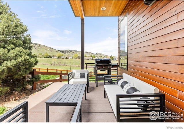view of patio / terrace featuring an outdoor living space, a grill, and a mountain view