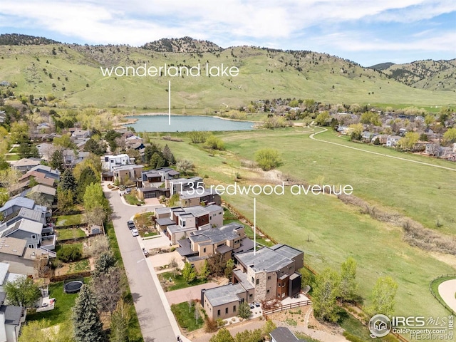drone / aerial view featuring a residential view and a water and mountain view