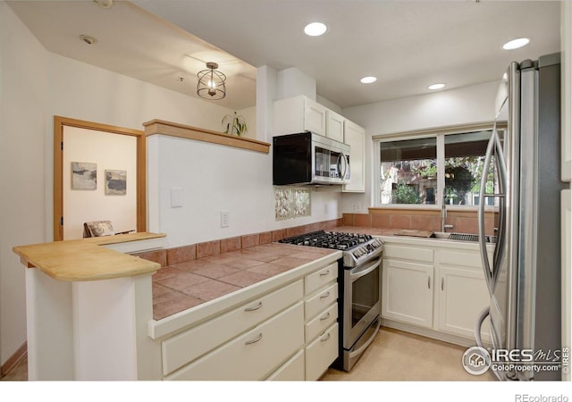 1460 Quince Ave Unit S102, Boulder, CO 80304 - kitchen with stainless steel appliances, a sink, white cabinetry, a peninsula, and recessed lighting