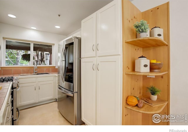 1460 Quince Ave Unit S102, Boulder, CO 80304 - kitchen featuring stainless steel appliances, open shelves, tile countertops, a sink, and white cabinetry