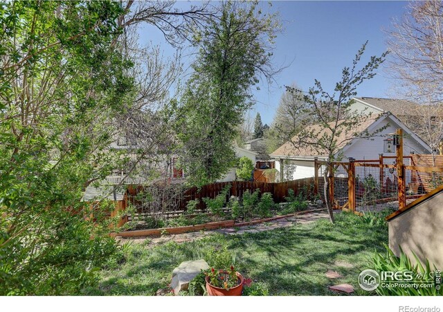1460 Quince Ave Unit S102, Boulder, CO 80304 - view of yard featuring a vegetable garden and an attached garage