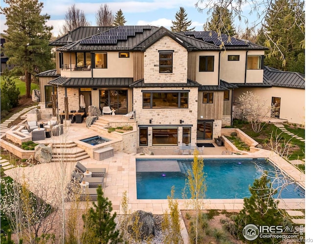 2158 Tamarack Ave, Boulder, CO 80304 - rear view of property featuring an outdoor living space with a fire pit, a balcony, a standing seam roof, roof mounted solar panels, and metal roof