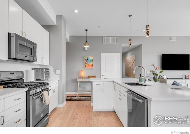 kitchen with a sink, light wood-style floors, stainless steel appliances, and visible vents