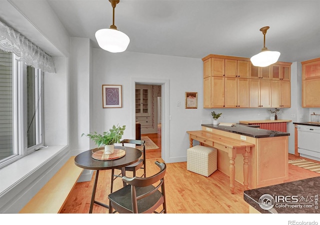 807 Collins St, Eaton, CO 80615 - kitchen with dark countertops, light brown cabinetry, pendant lighting, and light wood-type flooring