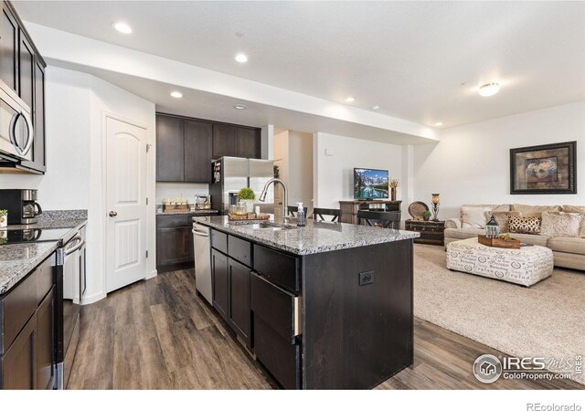 4355 24th Street Rd Unit 202, Greeley, CO 80634 - kitchen with appliances with stainless steel finishes, a sink, a kitchen island with sink, open floor plan, and dark wood-type flooring