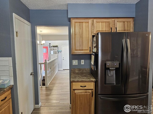 1628 Pheasant Rdg, Sterling, CO 80751 - kitchen featuring a textured ceiling, wood finished floors, baseboards, a chandelier, and black fridge