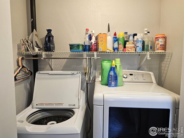 1628 Pheasant Rdg, Sterling, CO 80751 - clothes washing area featuring washing machine and clothes dryer, laundry area, and a textured wall