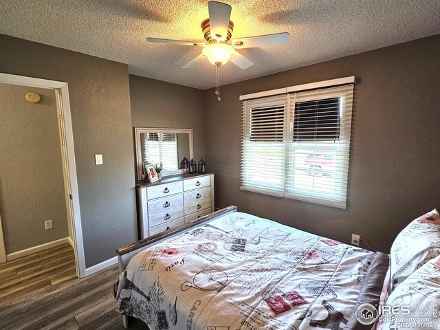 1628 Pheasant Rdg, Sterling, CO 80751 - bedroom featuring a ceiling fan, a textured ceiling, dark wood finished floors, and baseboards