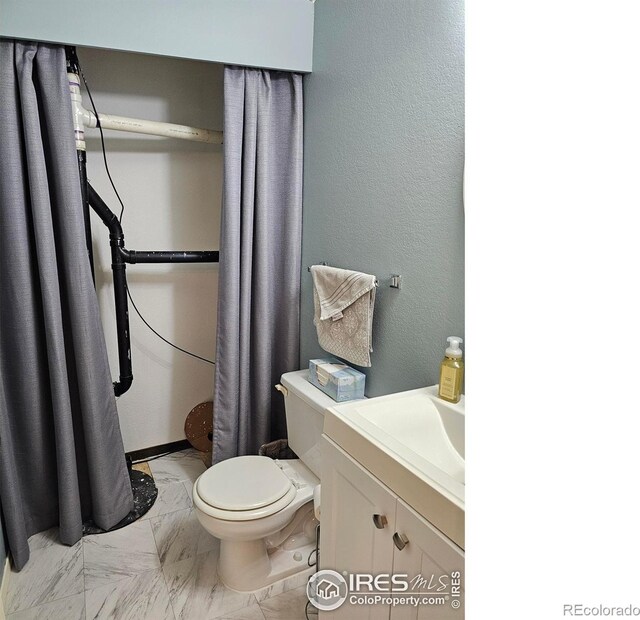 1628 Pheasant Rdg, Sterling, CO 80751 - bathroom featuring vanity, marble finish floor, and toilet