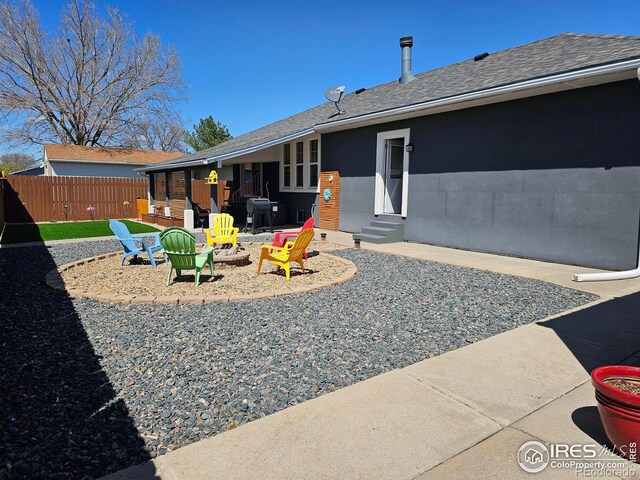 1628 Pheasant Rdg, Sterling, CO 80751 - rear view of property with roof with shingles, a patio area, fence, a fire pit, and entry steps
