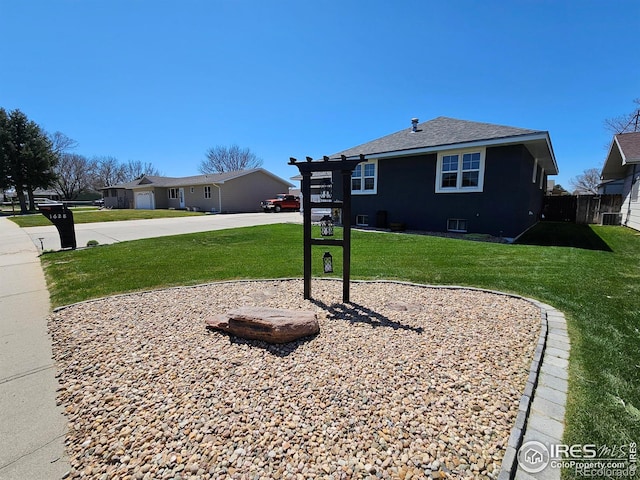 1628 Pheasant Rdg, Sterling, CO 80751 - view of front of property featuring central AC, fence, a front lawn, concrete driveway, and a shingled roof