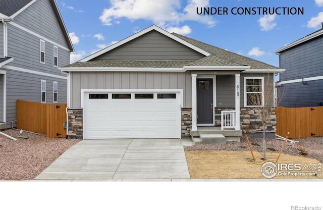 6500 13th St, Frederick, CO 80530 - craftsman-style home with a shingled roof, a garage, driveway, stone siding, and board and batten siding