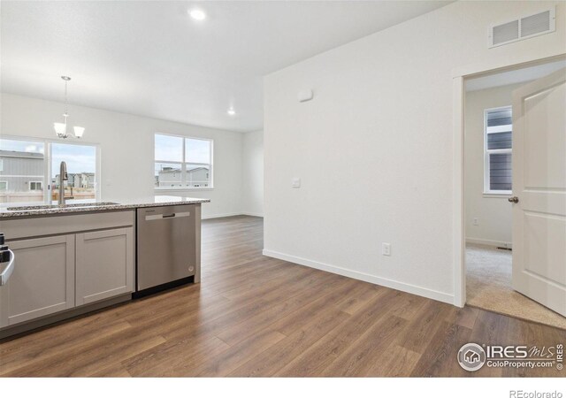 6500 13th St, Frederick, CO 80530 - kitchen featuring dishwasher, a sink, wood finished floors, baseboards, and a chandelier