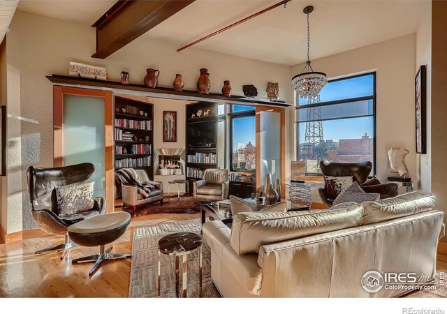 210 W Magnolia St Unit 320, Fort Collins, CO 80521 - living area with an inviting chandelier, beam ceiling, and wood finished floors