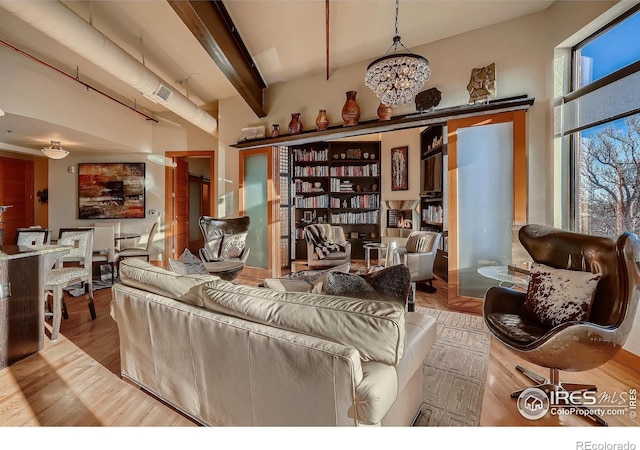 210 W Magnolia St Unit 320, Fort Collins, CO 80521 - living area with an inviting chandelier, beamed ceiling, wood finished floors, and visible vents