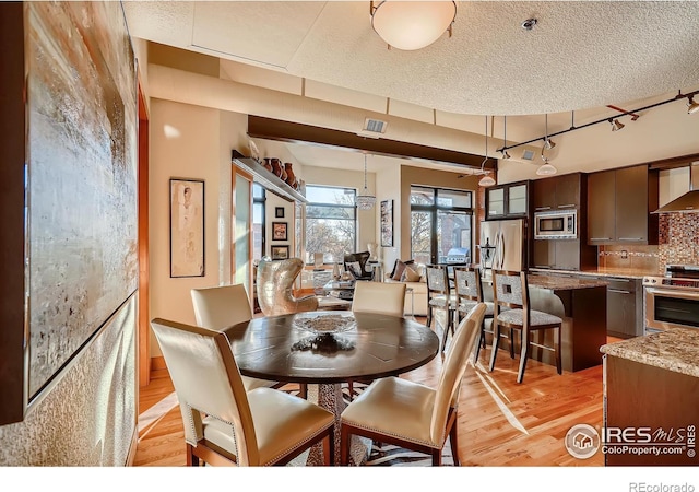 210 W Magnolia St Unit 320, Fort Collins, CO 80521 - dining space featuring visible vents and light wood-style flooring