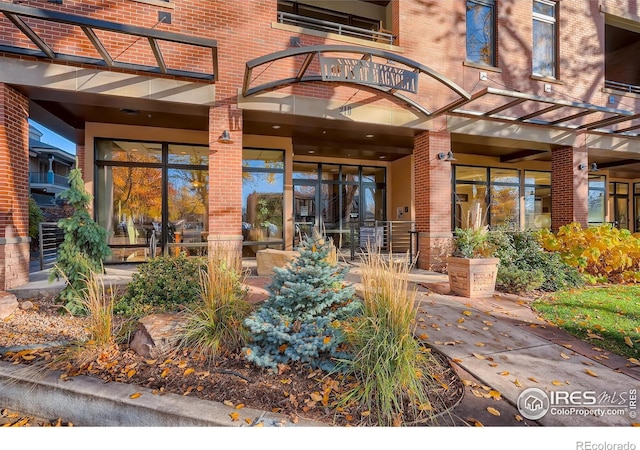 210 W Magnolia St Unit 320, Fort Collins, CO 80521 - view of exterior entry with brick siding and a balcony