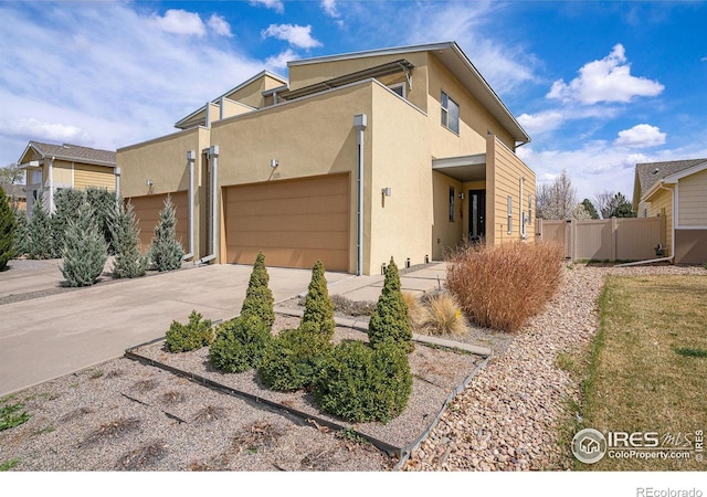 156 Brass Ct Unit 156, Loveland, CO 80537 - adobe home featuring concrete driveway, a garage, stucco siding, and fence