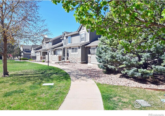 2203 Copper Creek Dr Unit D, Fort Collins, CO 80528 - view of front of house with board and batten siding, stone siding, a residential view, and a front yard