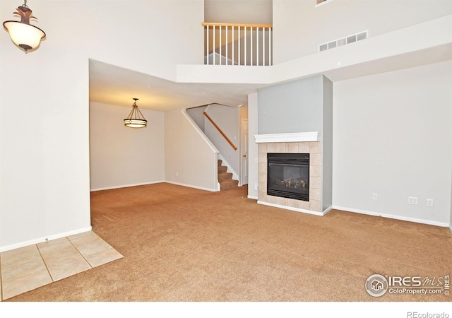 2203 Copper Creek Dr Unit D, Fort Collins, CO 80528 - unfurnished living room featuring baseboards, visible vents, carpet, and a towering ceiling