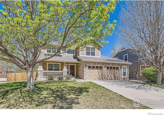 1602 Prairie Song Pl, Longmont, CO 80504 - traditional-style house featuring covered porch, fence, concrete driveway, and stone siding